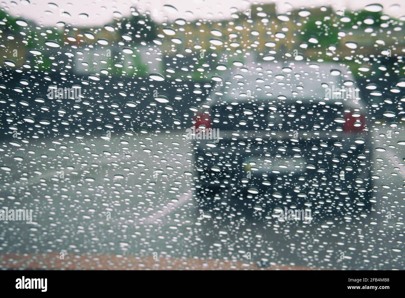 Pluie d'automne sur le verre de voiture, mise au point sélective sur le raindrop. Gouttes d'eau sur la fenêtre. Banque D'Images