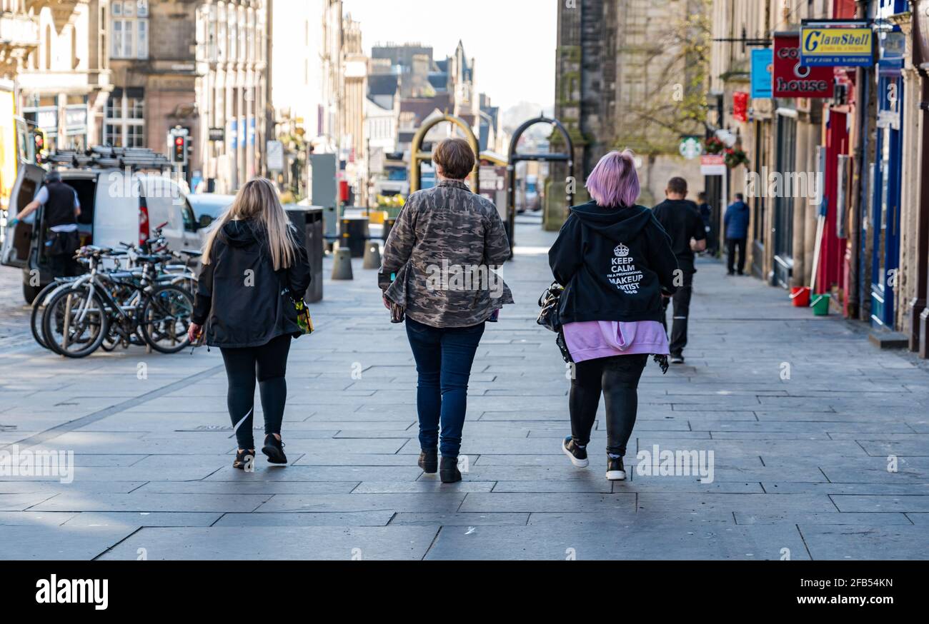 Trois femmes composent des artistes qui marchent sur la partie Royal Mile de l'équipe de tournage pendant le tournage à Édimbourg, en Écosse, au Royaume-Uni Banque D'Images