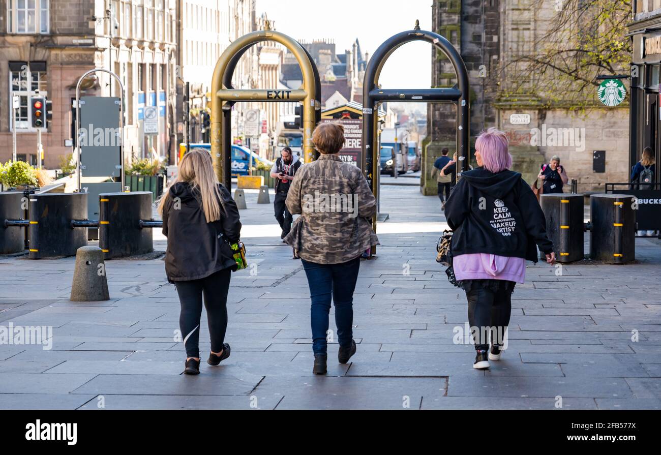 Trois femmes composent des artistes qui marchent sur la partie Royal Mile de l'équipe de tournage pendant le tournage à Édimbourg, en Écosse, au Royaume-Uni Banque D'Images