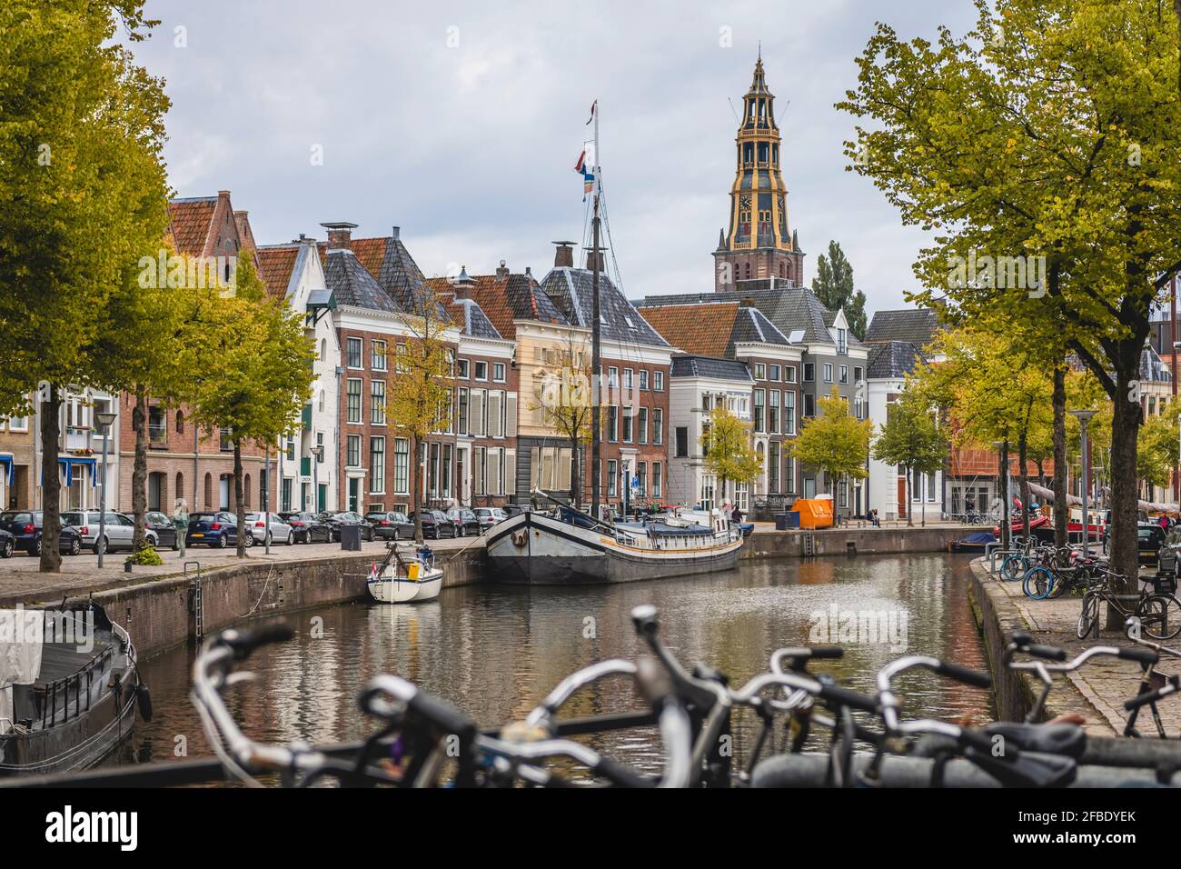 Pays-Bas, Groningen, canal de la ville avec rangée de maisons en arrière-plan Banque D'Images