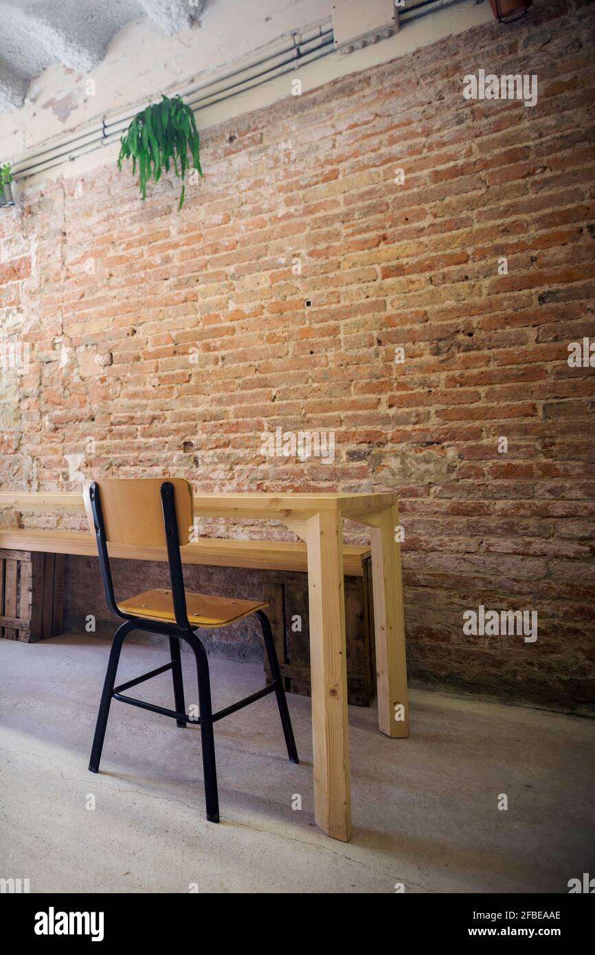 Chaise et table vide à l'intérieur devant la brique mur Banque D'Images