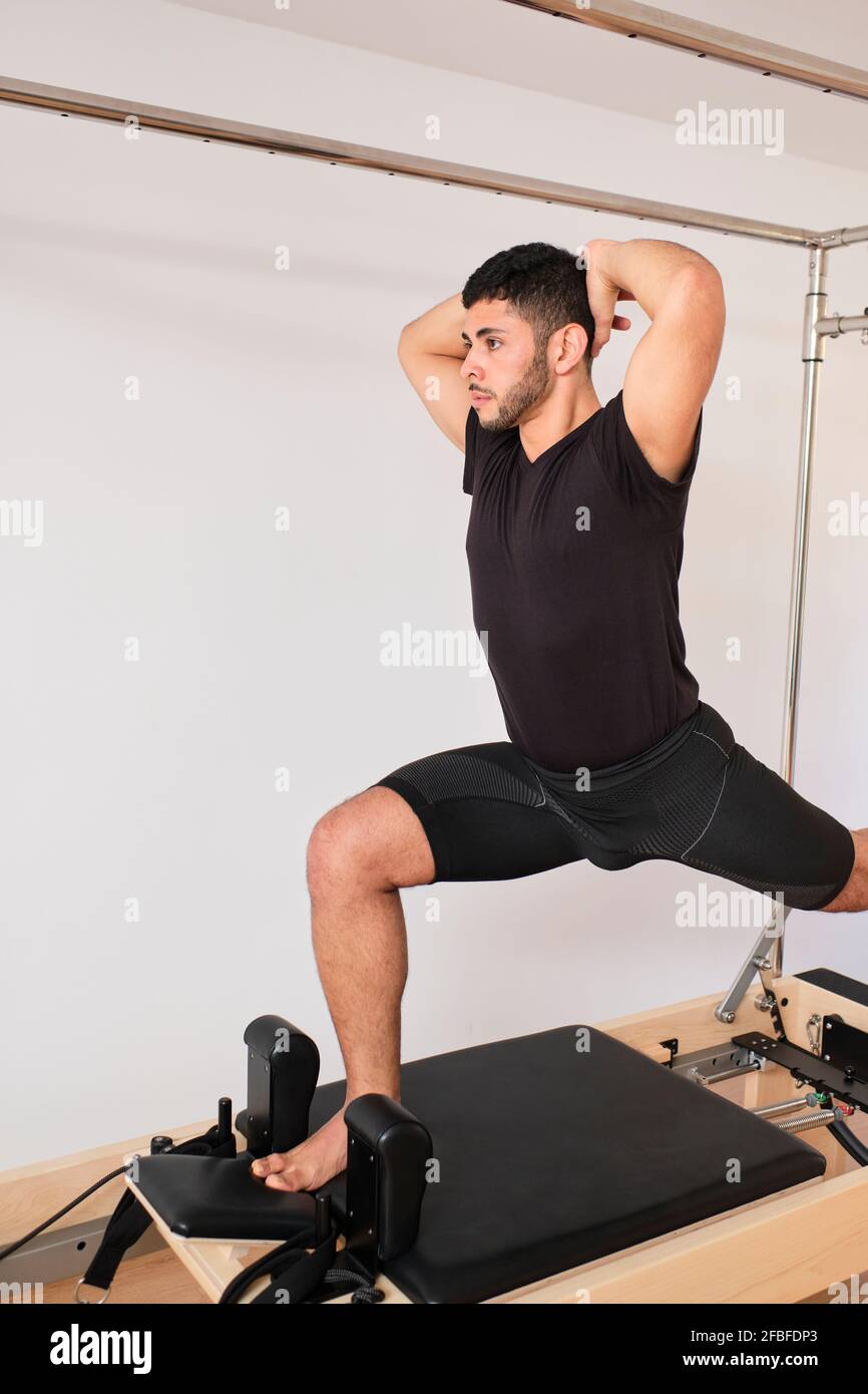 Athlète masculin concentré pratiquant les pilates dans la salle d'exercice Banque D'Images