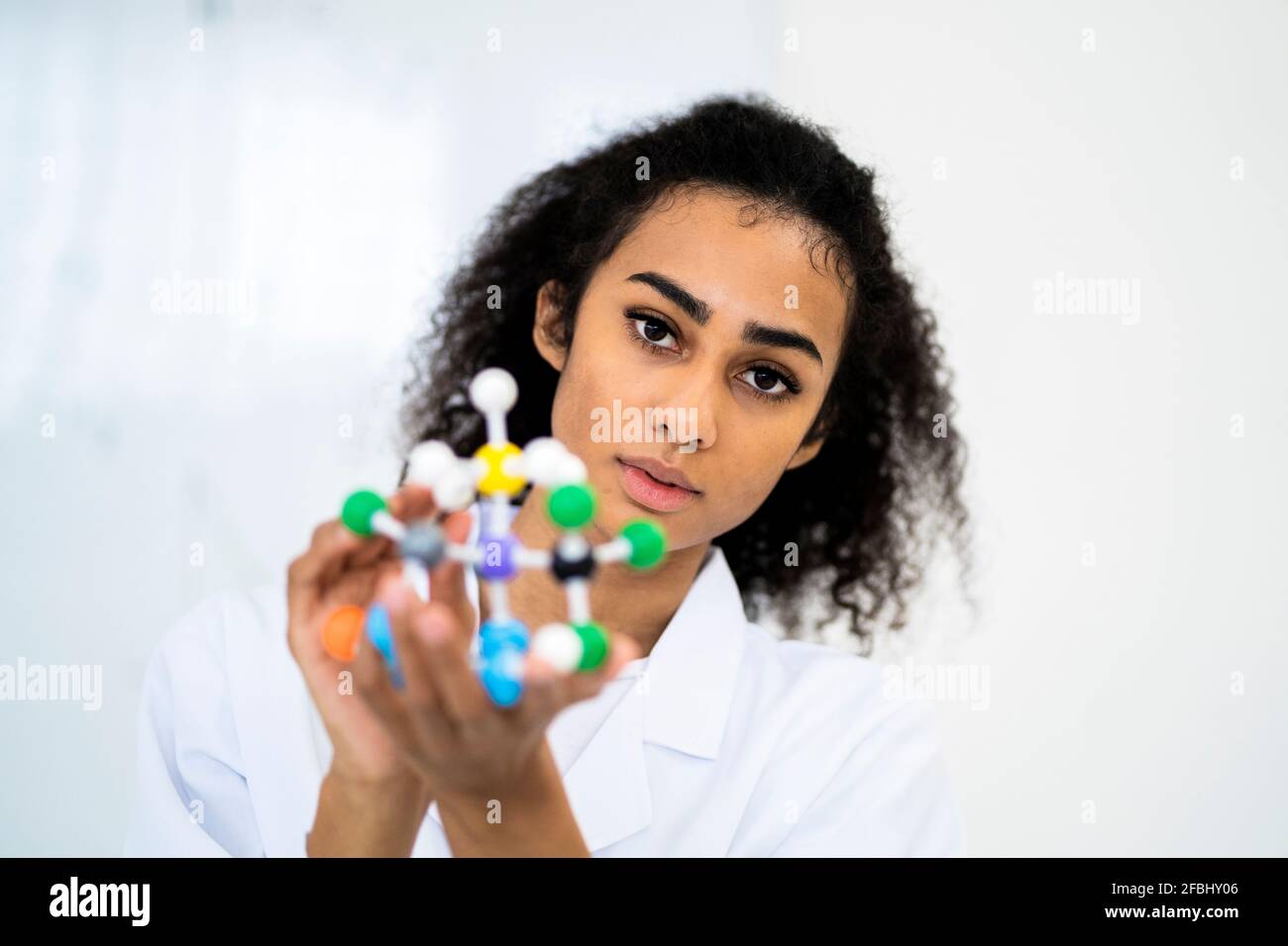 Jeune chercheur ayant une structure moléculaire en laboratoire Banque D'Images