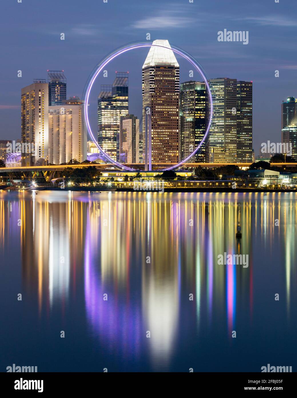 Singapour, longue exposition de Marina Bay au crépuscule avec Singapore Flyer et gratte-ciels du centre-ville en arrière-plan Banque D'Images