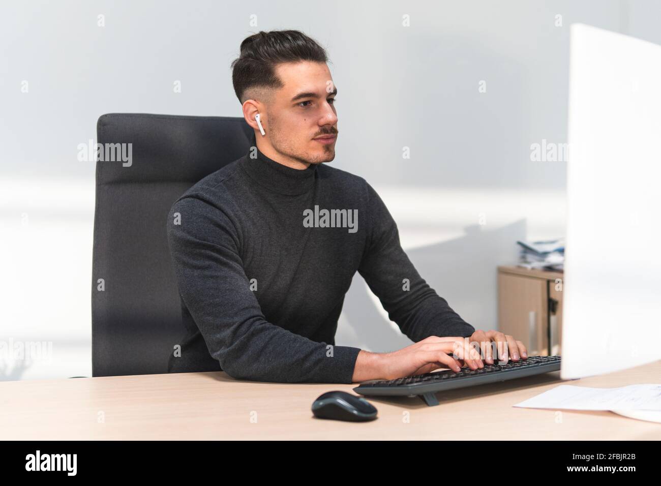 Jeune homme d'affaires travaillant sur un ordinateur au bureau Banque D'Images