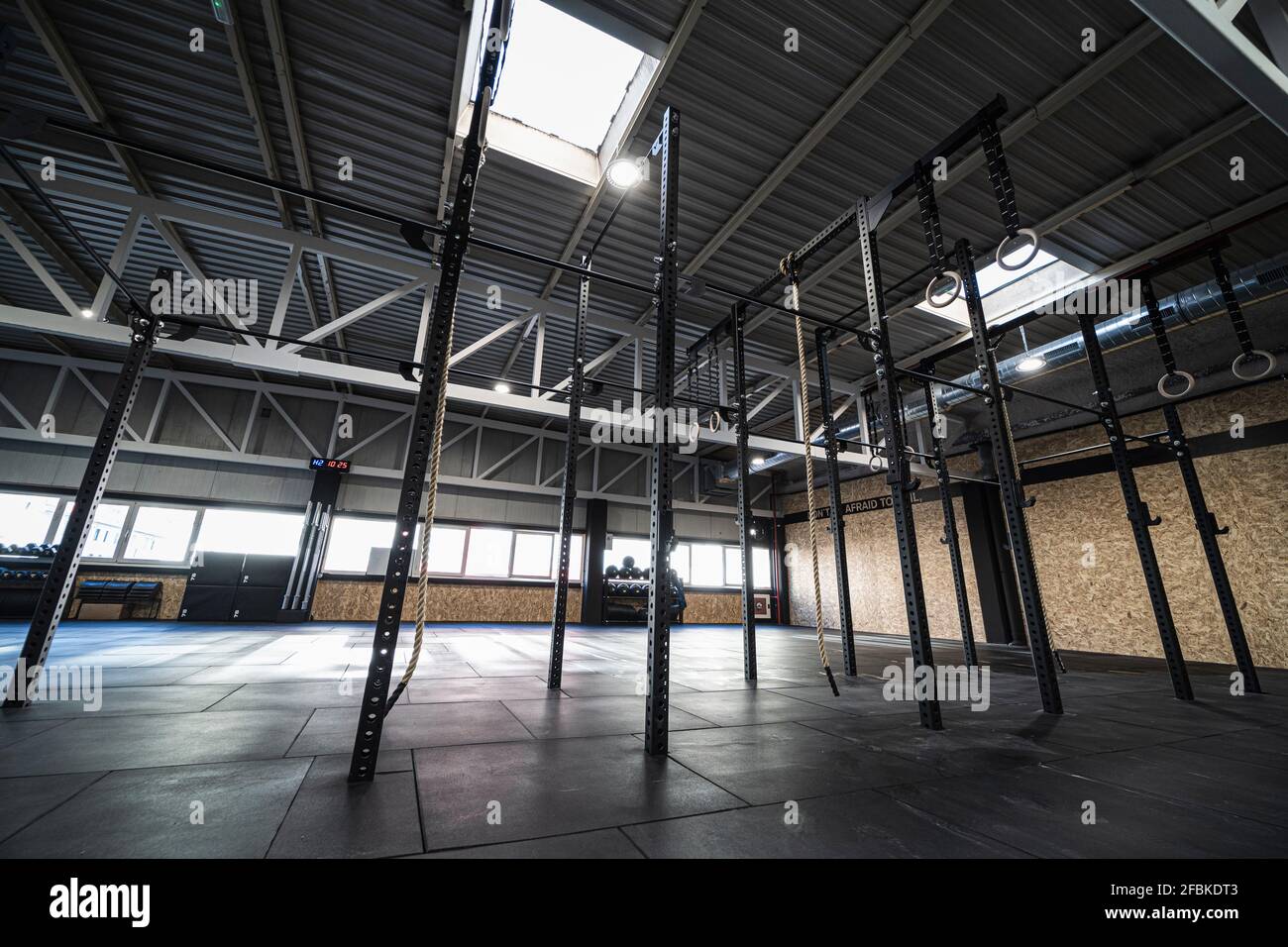Anneaux et cordes de gymnastique suspendus dans la salle de gym vide Banque D'Images