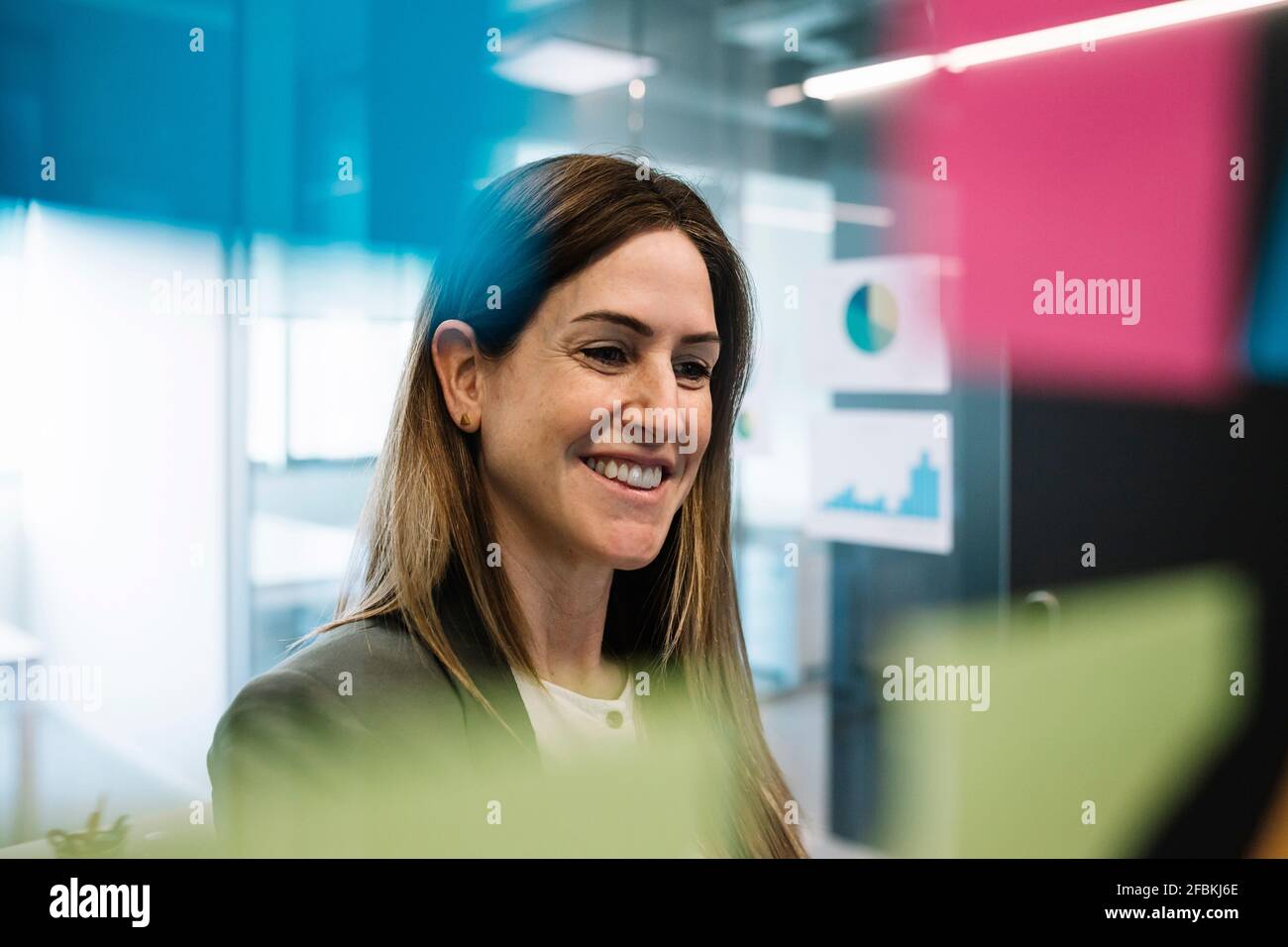 Femme entrepreneur regardant la stratégie sur le mur de verre au bureau Banque D'Images