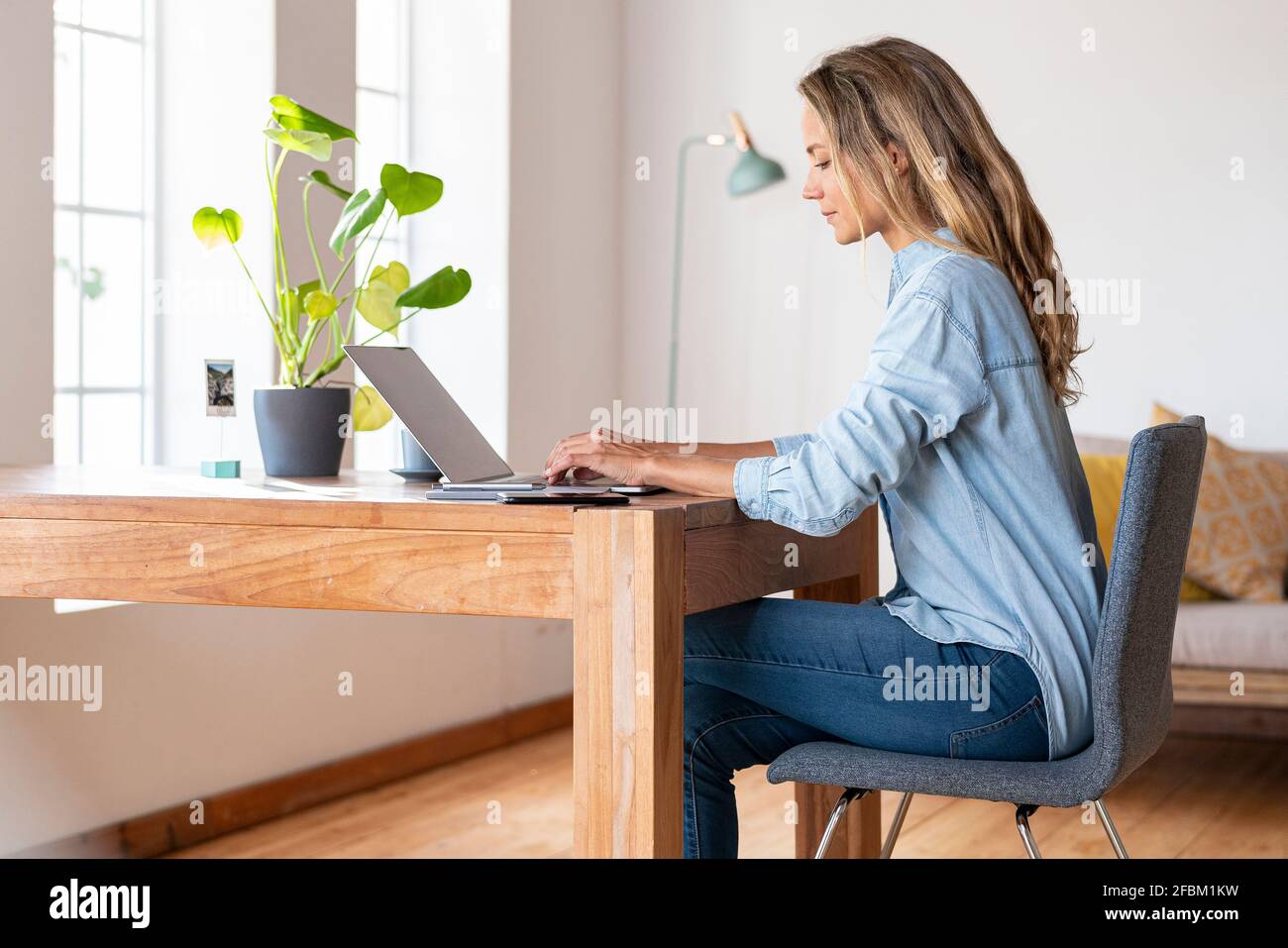 Femme d'affaires concentrée travaillant sur un ordinateur portable au bureau à domicile Banque D'Images