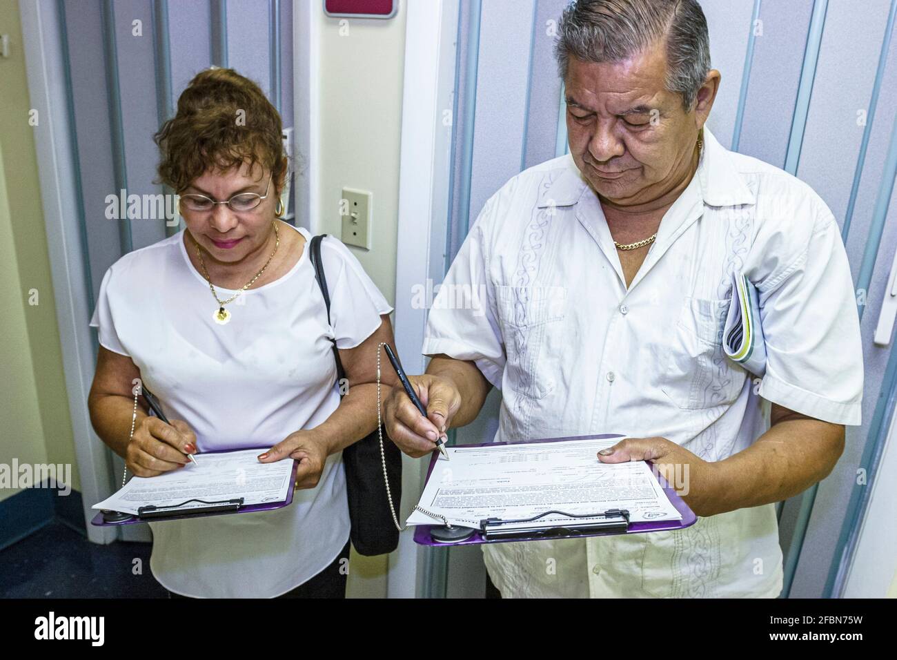 Miami Beach Florida, centre de santé communautaire, hispanique femme homme couple homme femme prise d'une entrevue d'enquête, co de dépistage gratuit Banque D'Images