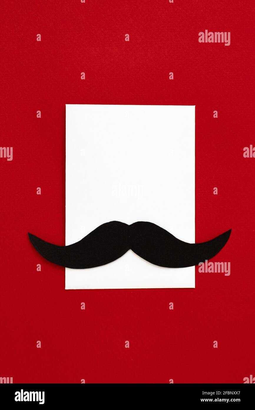 joyeux fête des pères, composition de la moustache noire sur l'enveloppe et espace vide pour le texte isolé sur fond rouge, carte de vœux avec feuille blanche de pap Banque D'Images
