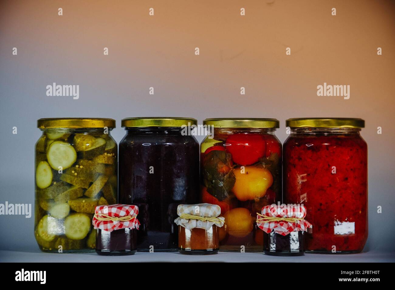 Bocaux avec des aliments de conservation, quatre plus grands et trois petits, en studio Banque D'Images