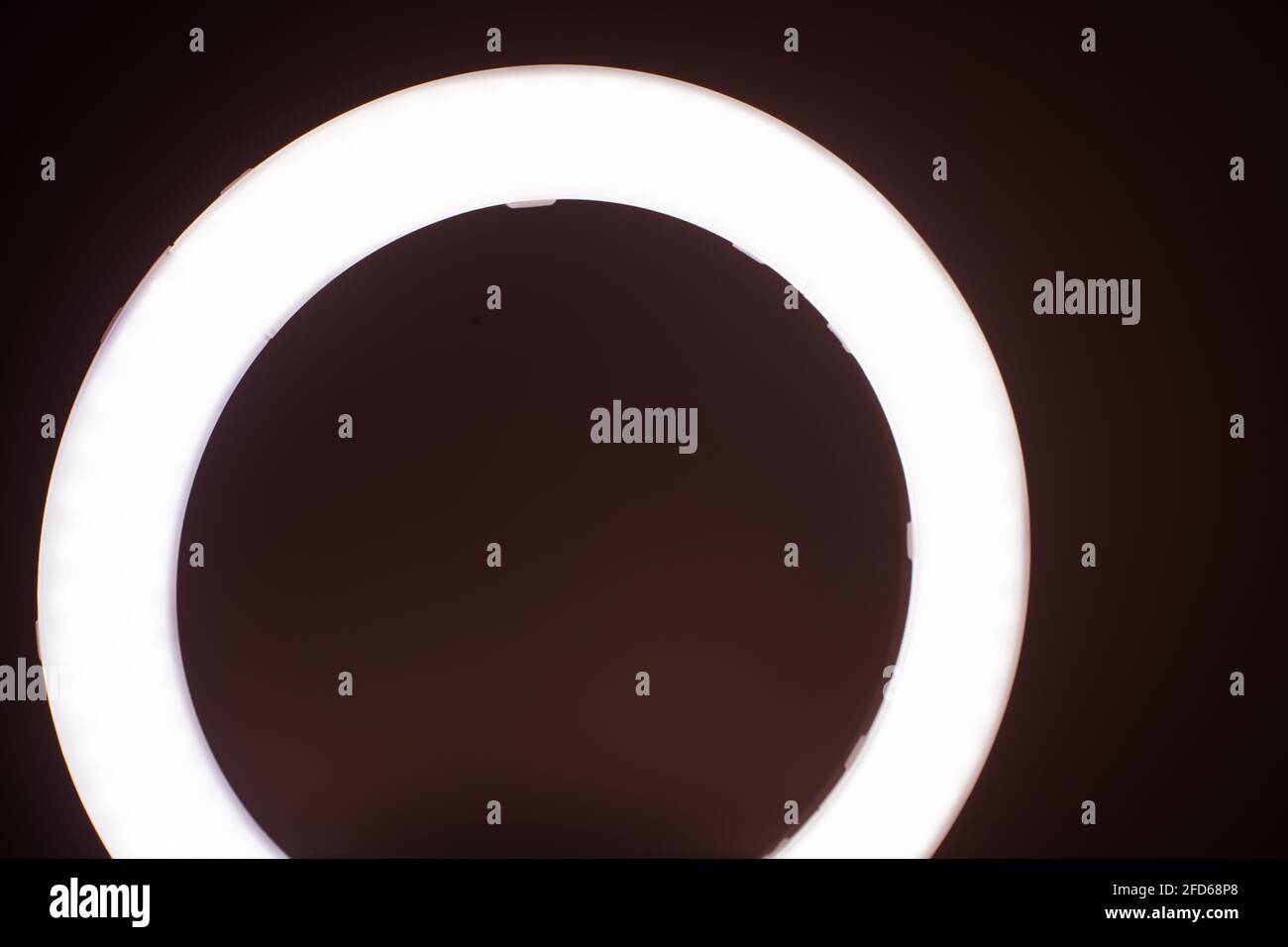 Grand anneau lumineux LED dans une salle de studio contre les murs vides vue de face. Banque D'Images