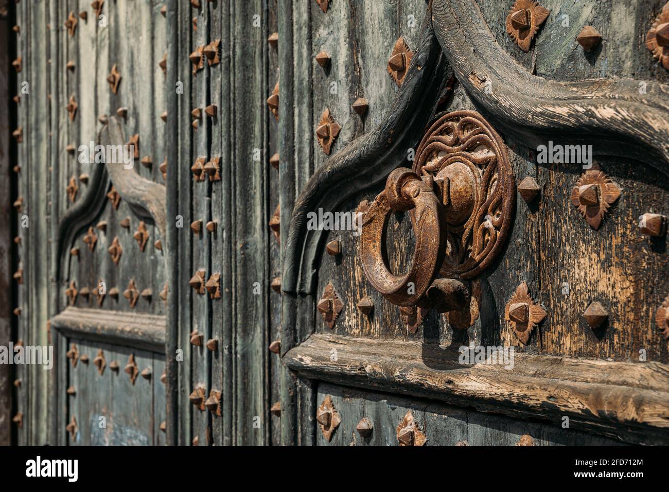 Détails du portail de la cathédrale. Porte-perce en métal sur les anciennes portes en bois renforcées de fer forgé à la cathédrale de Gérone, en Espagne Banque D'Images