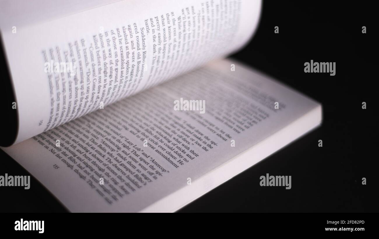Galle, Sri Lanka - 04 07 2021: Défilement de pages du célèbre roman de J.R.R.Tolkein. Livre ouvert isolé dans un fond noir foncé. Con Banque D'Images