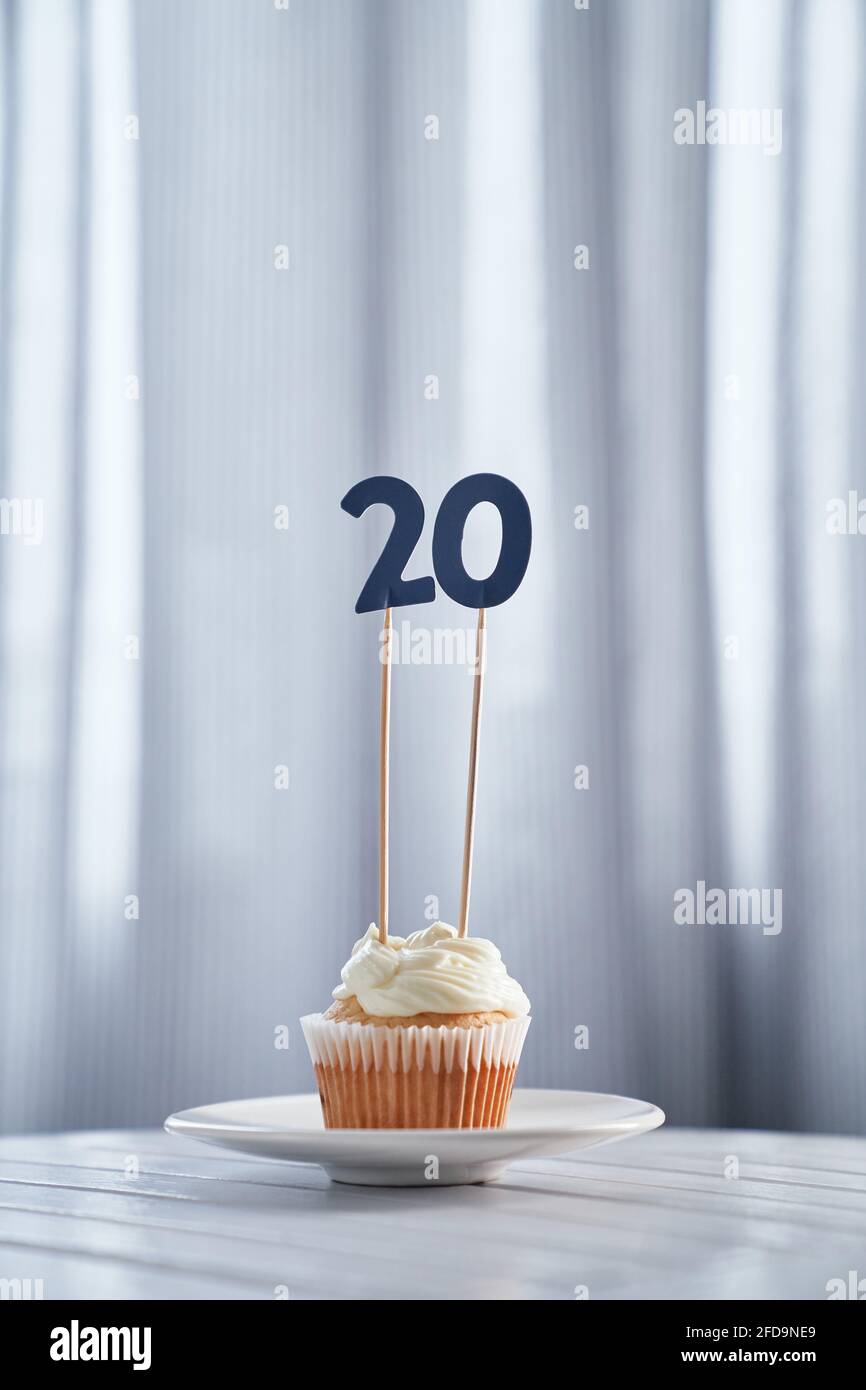 Savoureux Cupcake Maison Anniversaire Vanille Avec Garniture Cremeuse Et Numero Vingt Sur Plaque Blanche Et Fond Clair Concept De Carte D Invitation D Anniversaire Minimaliste Image Verticale De Haute Qualite Photo Stock