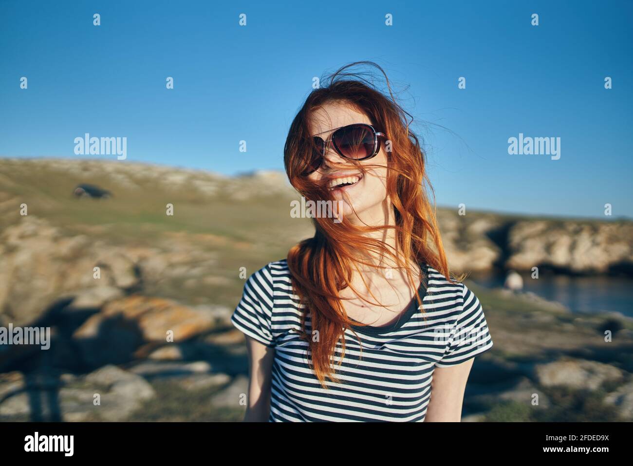 bonne femme en t-shirt rayé et lunettes de soleil montagnes et bleu ciel  vacances d'été Photo Stock - Alamy