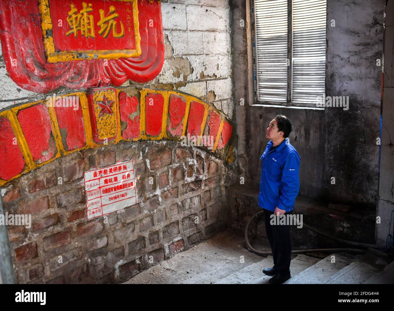 (210424) -- TAIYUAN, 24 avril 2021 (Xinhua) -- Zhang Hai se dresse devant un tunnel minier fermé à la mine Baijiazhuang de Shanxi Coking Coking Coking Coking Coking Coking Group, dans la province de Shanxi, au nord de la Chine, le 11 mars 2021. Zhang Lianggui, son fils Zhang Hai et son petit-fils Zhang Shiqi avaient tous travaillé comme mineurs de charbon. L'histoire de cette famille de mineurs de charbon sur trois générations illustre l'essor de l'industrie minière chinoise, de l'activité humaine à celle de la technologie. Près de 90 ans, Zhang Lianggui est un mineur à charbon à la retraite. Recruté en 1954, il rappelle les conditions de travail difficiles des mineurs de charbon Banque D'Images