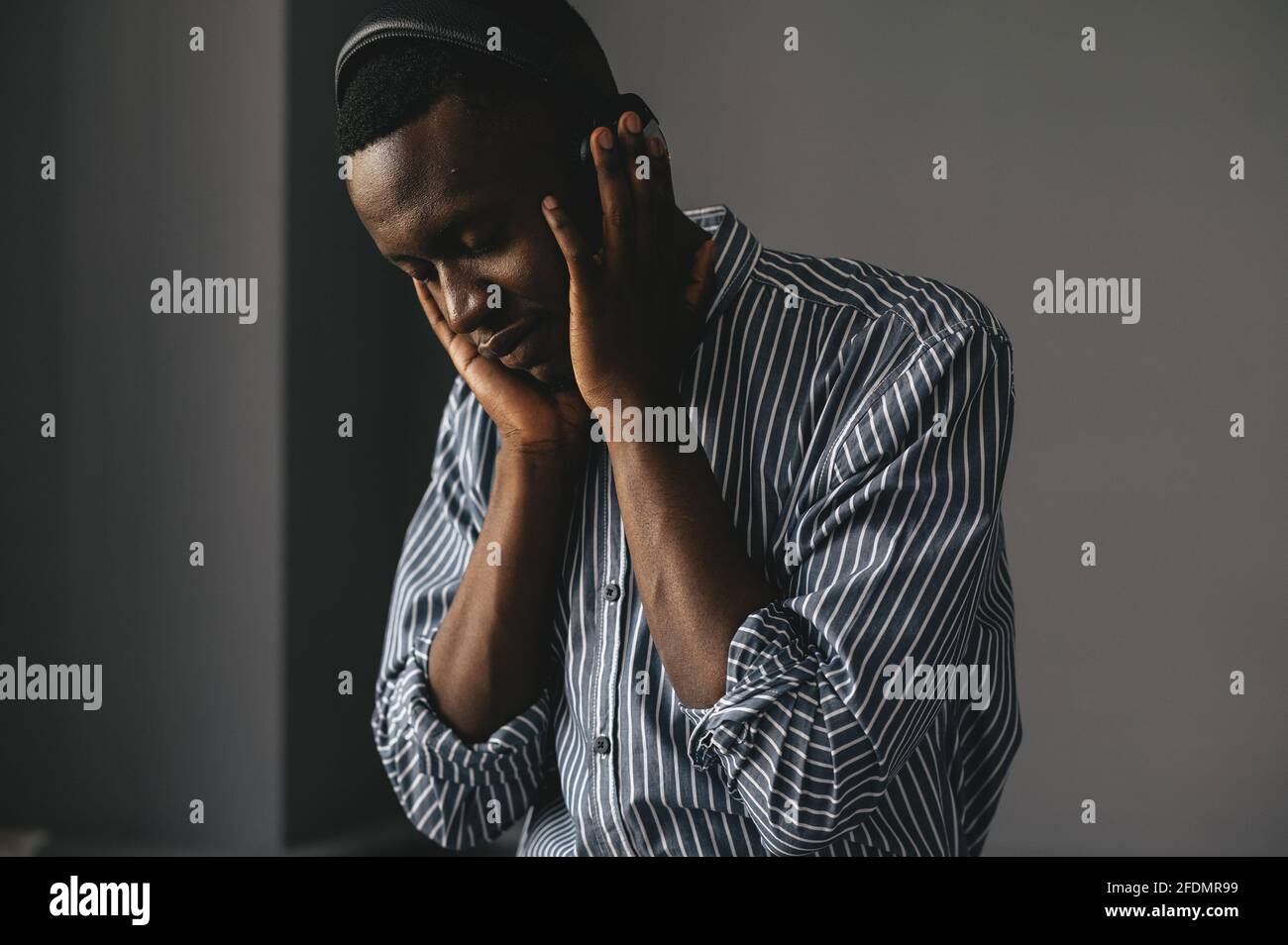 homme afro-américain dans une chemise élégante dans un casque d'écoute de la musique et de profiter de la musique, de la danse Banque D'Images