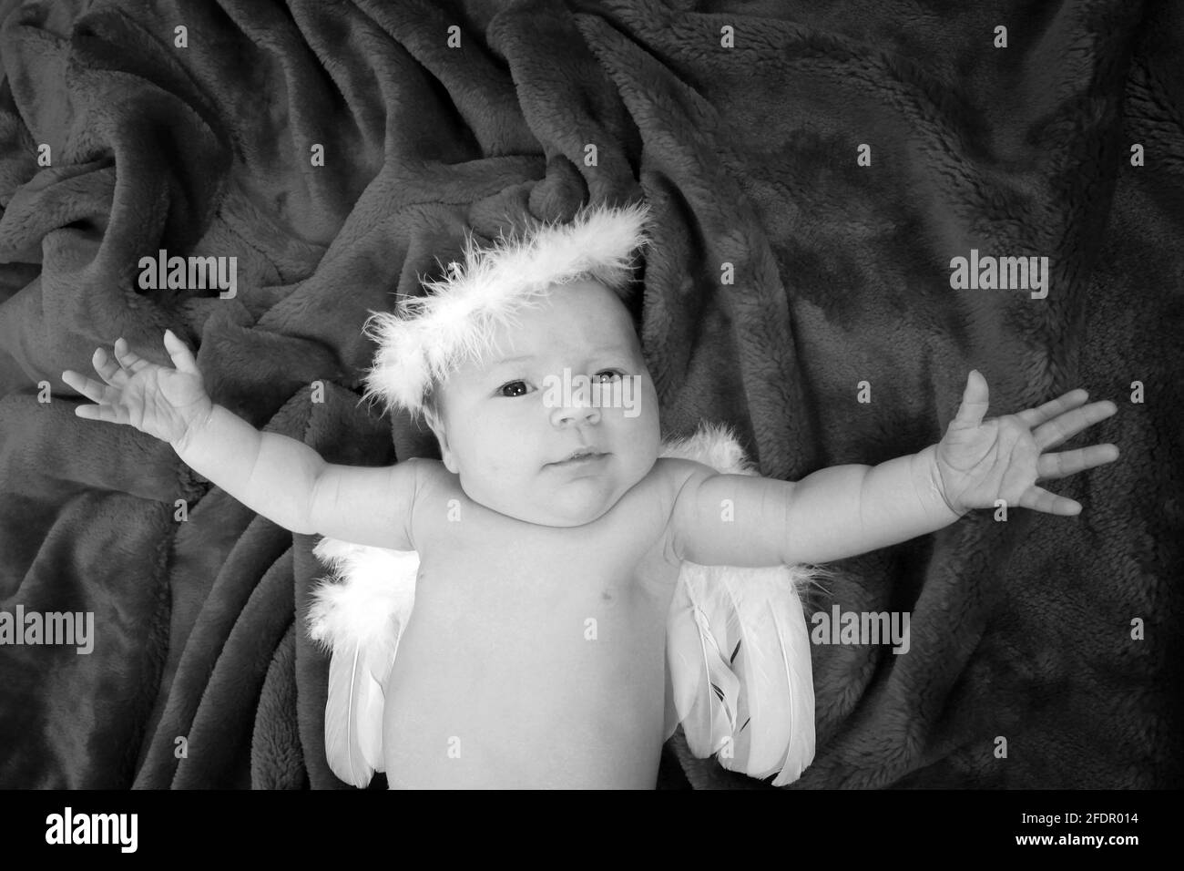 Nouveau-né robe de fille de bébé comme un ange sur doux couverture rouge Banque D'Images