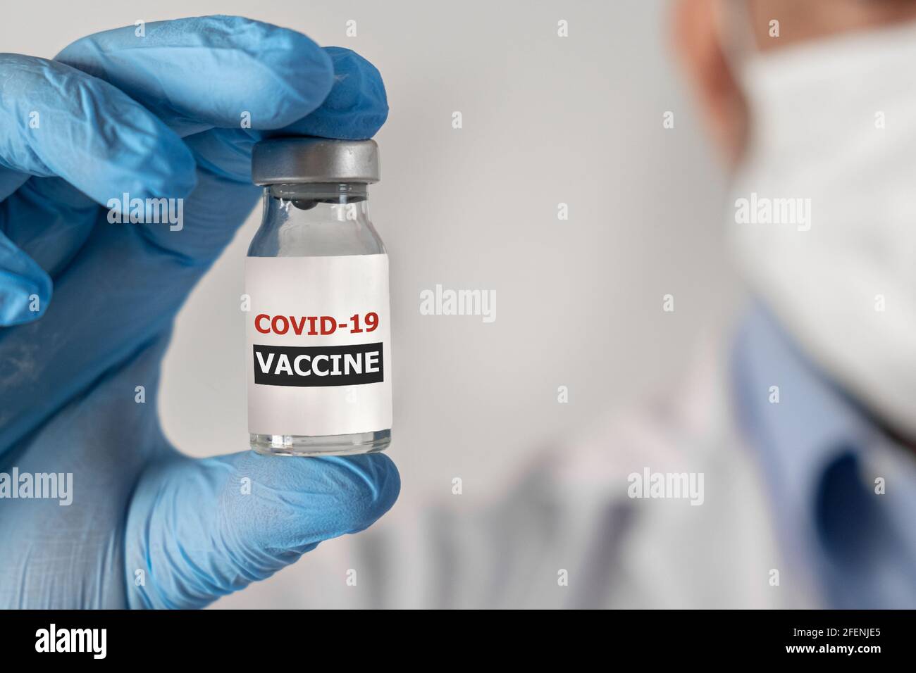 Concept de vaccination contre le coronavirus Covid-19 en main d'ampoule de bocal de vaccin en verre . Robe et gants blancs Banque D'Images