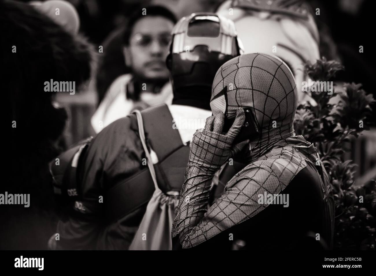 Image en noir et blanc d'un homme dans un Spiderman Costume parlant au téléphone à Times Square Banque D'Images