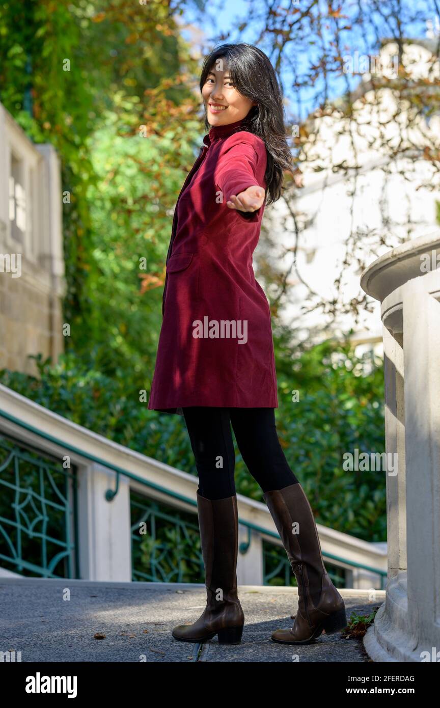 Belle femme chinoise avec de longs cheveux noirs le jour d'automne ensoleillé dans la ville, Banque D'Images