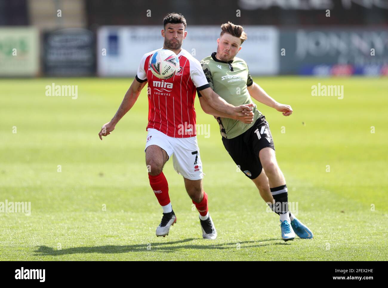 Le Conor Thomas de Cheltenham Town (à gauche) et le Noah Chilvers de Colchester United (à droite) se battent pour le ballon lors du match de la Sky Bet League Two au stade Jonny-Rocks, Cheltenham. Date de la photo: Samedi 24 avril 2021. Banque D'Images