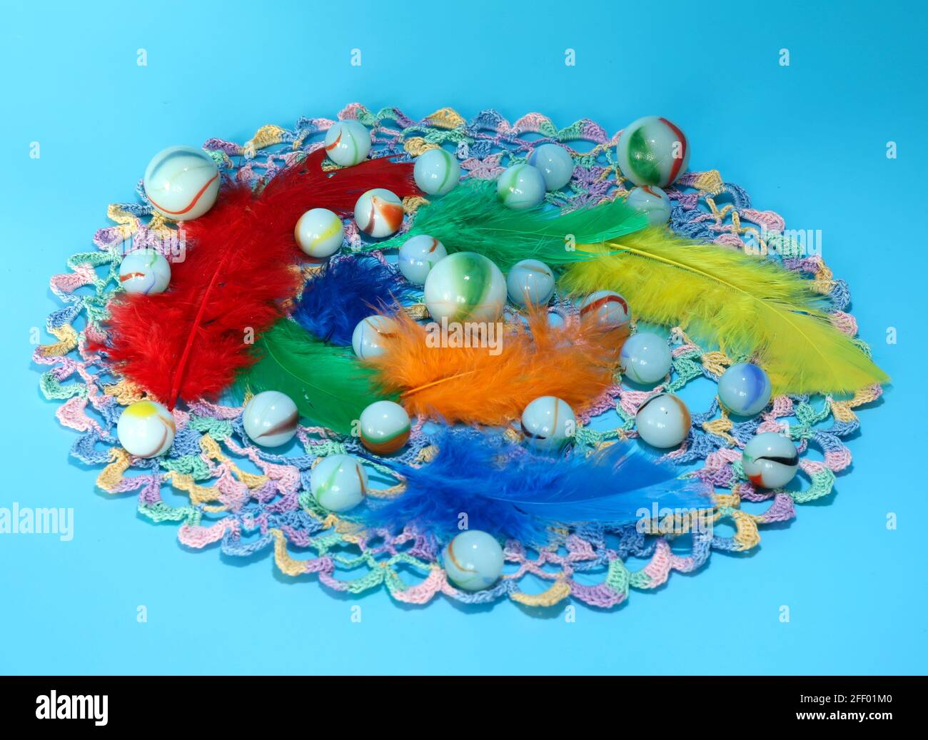 Une image de billes de verre et de plumes colorées Banque D'Images