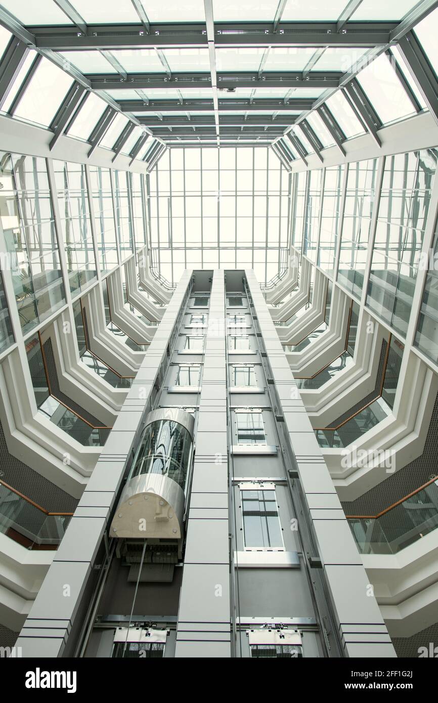 Vue sur le hall de bureau : toit rond et murs vitreux dans un hall moderne avec ascenseur Banque D'Images