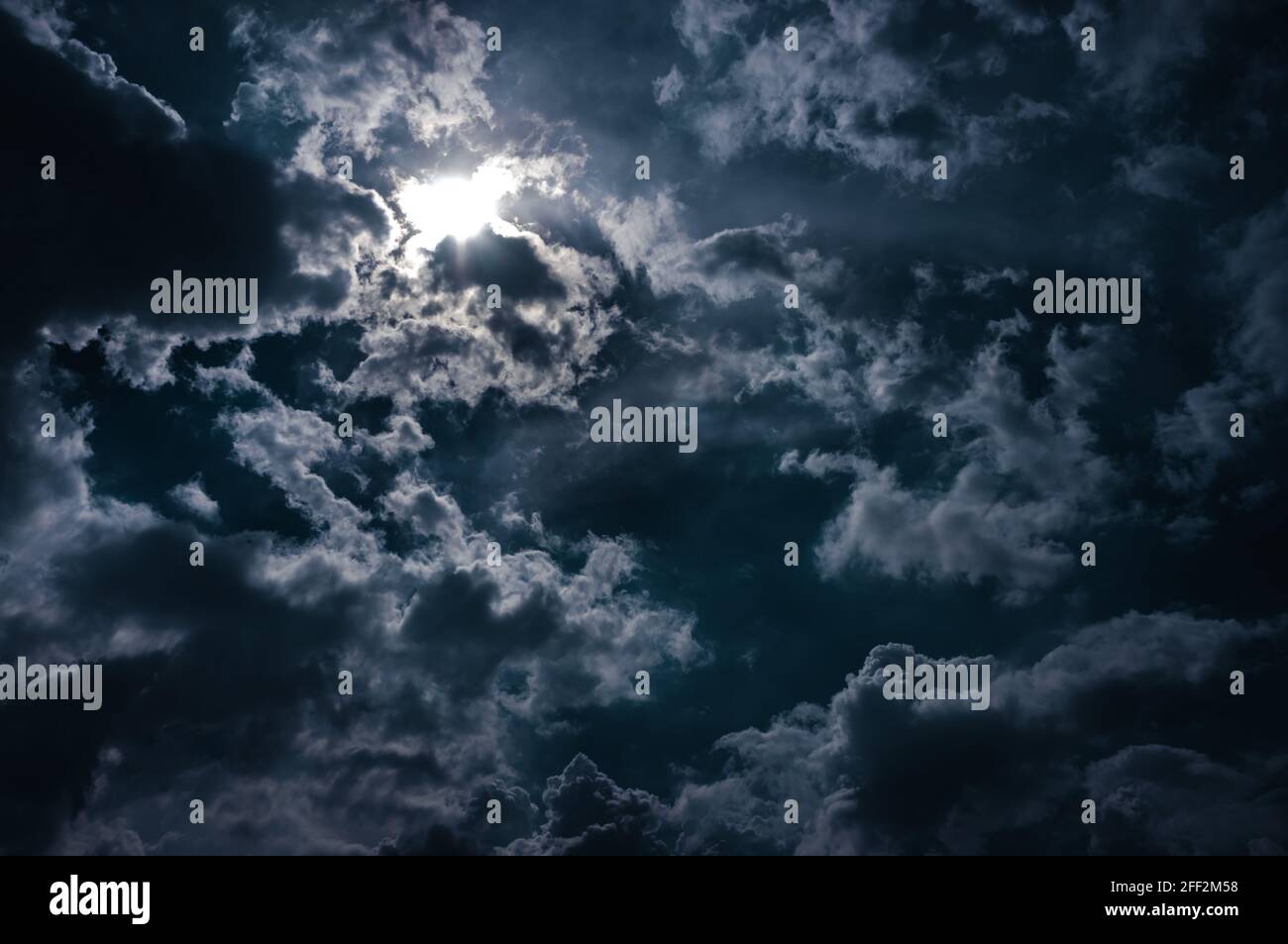 Clair de lune brille derrière un ciel nuageux la nuit. Sérénité nature fond. Banque D'Images