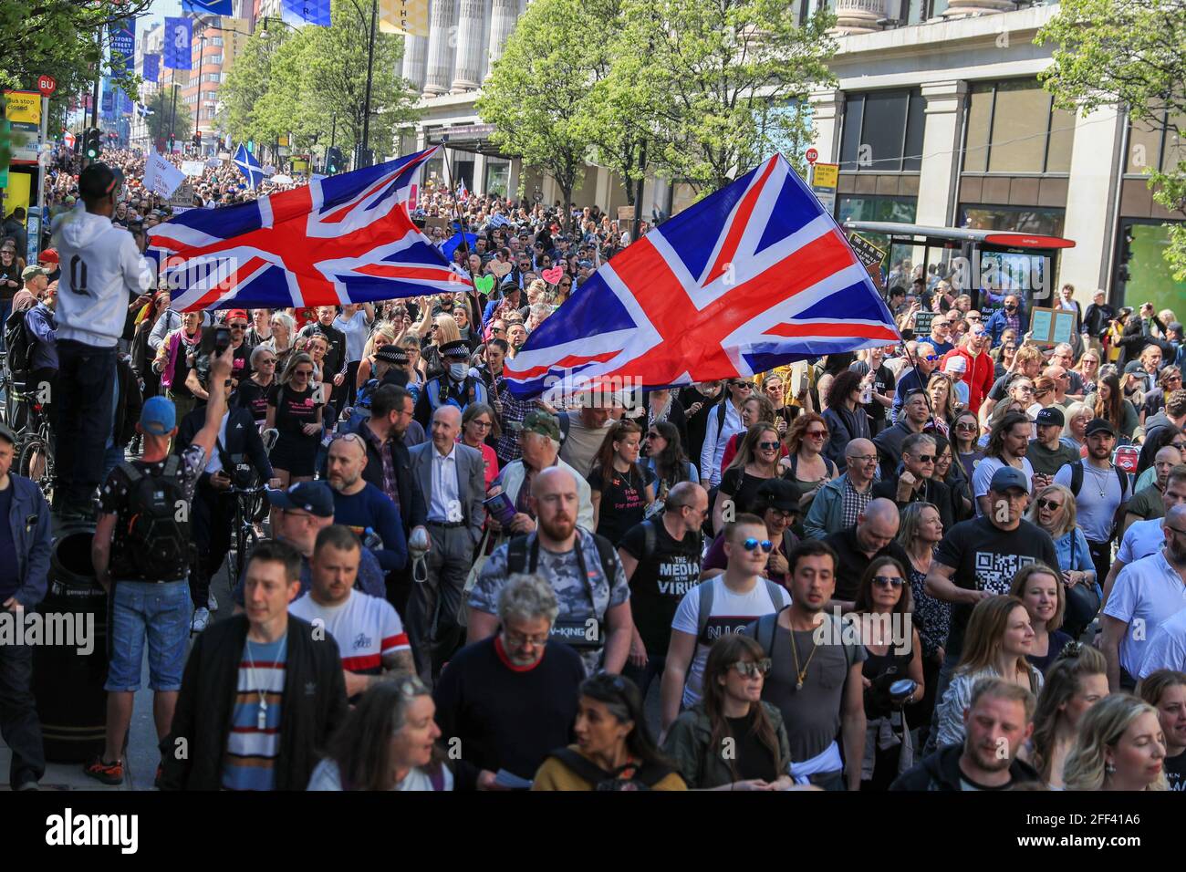Londres, Royaume-Uni. 24 avril 2021. Les manifestants défilent dans les rues tout en tenant les drapeaux du Royaume-Uni pendant la manifestation. Les gens ont appelé en ligne à un rassemblement de masse de type mob éclair contre le passeport vaccinal, les masques faciaux et le verrouillage. Le gouvernement vise à fournir une preuve officielle de vaccination à des millions de vacanciers britanniques cet été, dès le 17 mai. Crédit : SOPA Images Limited/Alamy Live News Banque D'Images