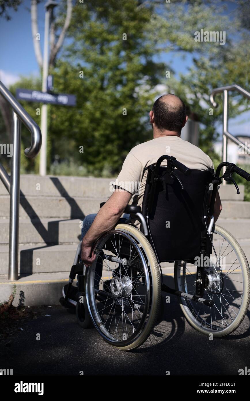 Utilisateur de chaise roulante à l'escalier du poste, barrière d'accessibilité sans mobilité Banque D'Images