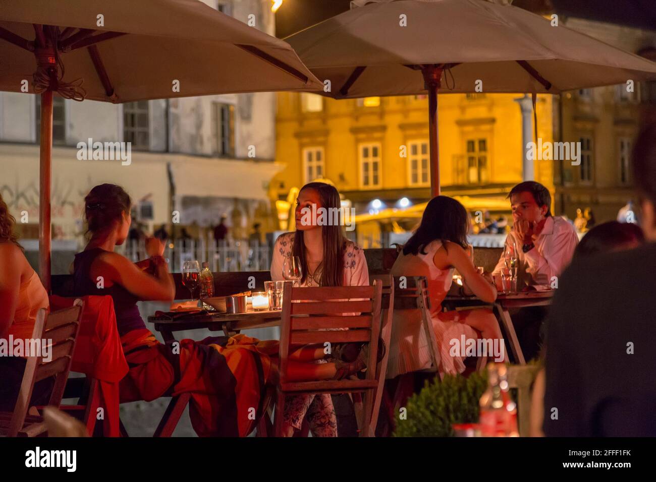 Personnes à des tables devant le restaurant et le bar le soir, Ljobljnana, Slovénie Banque D'Images