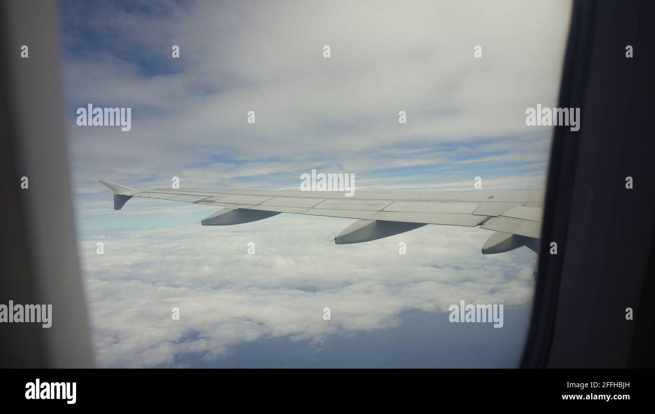 Hublot de l'avion avec bleu de la mer ou l'océan et d'îles tropicales. À la fenêtre par avion au cours du vol. Aile d'avion à travers le hublot. À la recherche d'aéronefs par la fenêtre pendant le vol. Banque D'Images