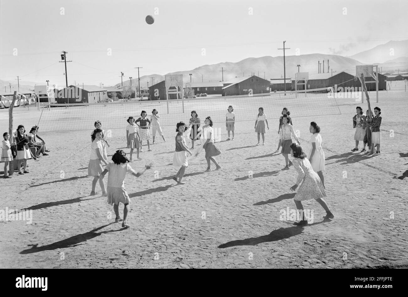 Filles japonaises-américaines jouant au volley-ball, Manzanar Relocation Center, Californie, États-Unis, Ansel Adams, Collection Manzanar War Relocation Centre, 1943 Banque D'Images