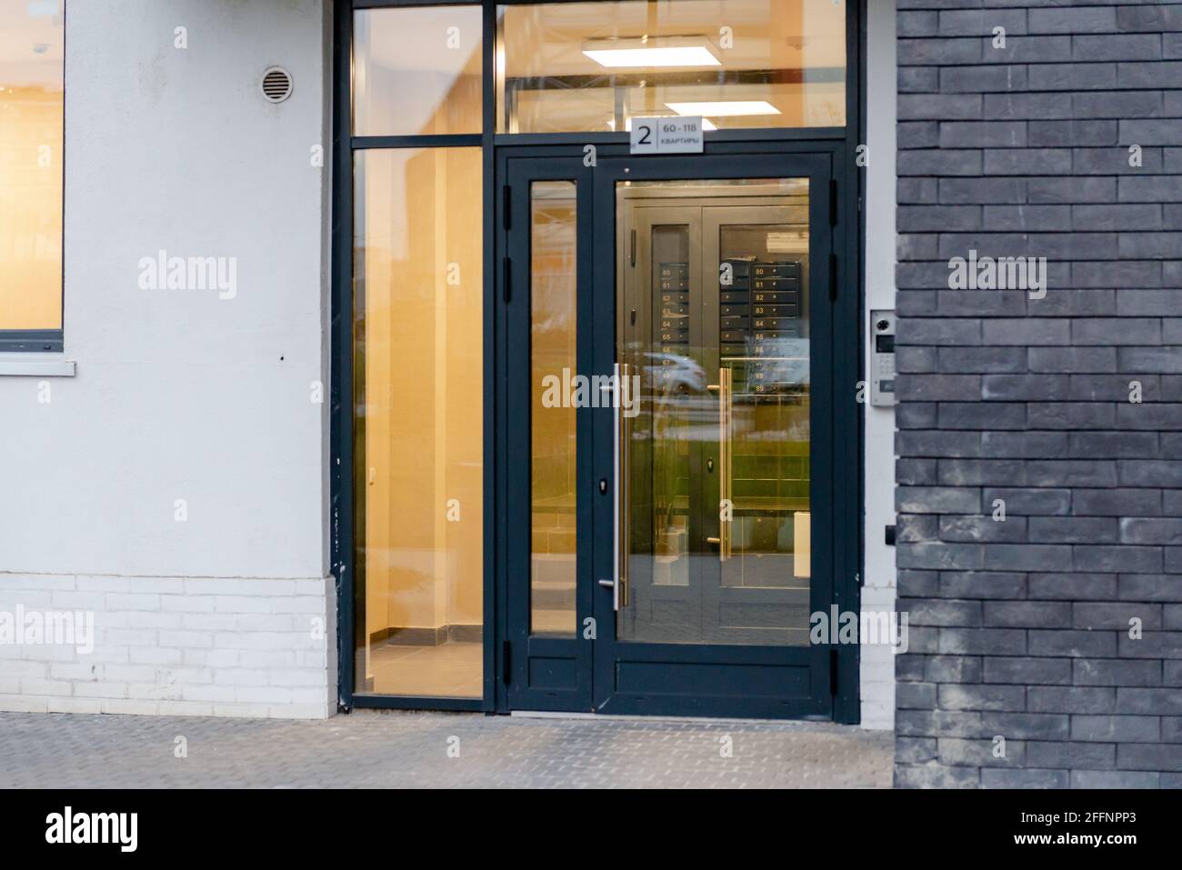 Entrée à un nouvel immeuble. Porte vitrée à l'entrée. Entrée à la maison sans escaliers. Les boîtes aux lettres sont visibles à travers la vitre. Banque D'Images