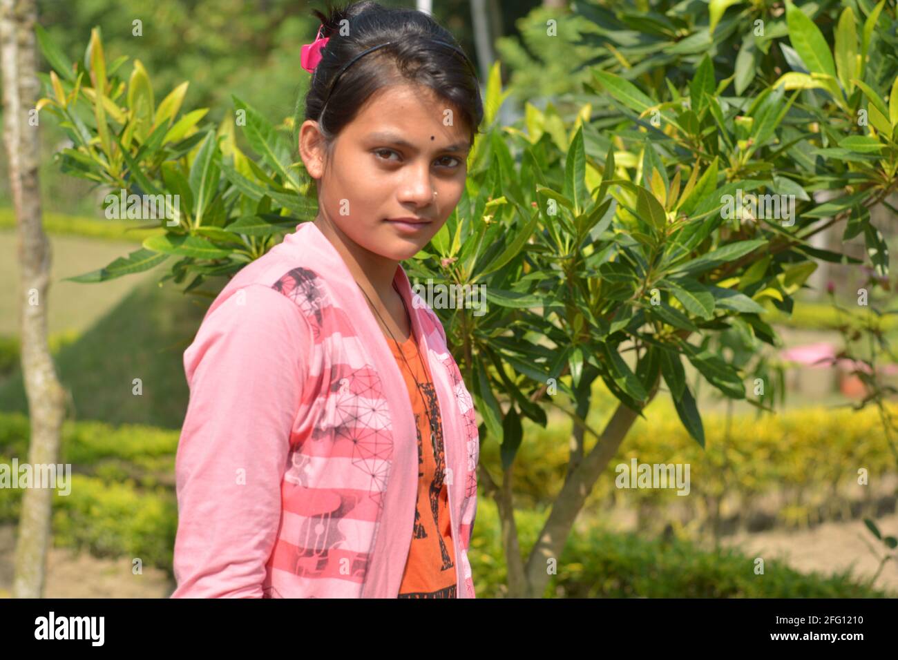 Adolescente indienne bengali portant des jeans mains sur la poche posant pour la photo dans un jardin, focalisation sélective Banque D'Images