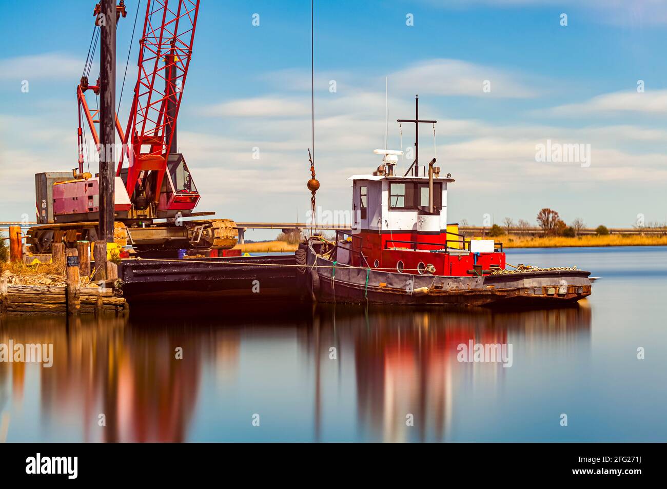 Un petit bateau de remorquage rustique d'époque avec peinture écaillée amarré par une grue sur la rivière Nanticoke. Une image artistique fine longue exposition avec de l'eau douce et du RU soyeux Banque D'Images