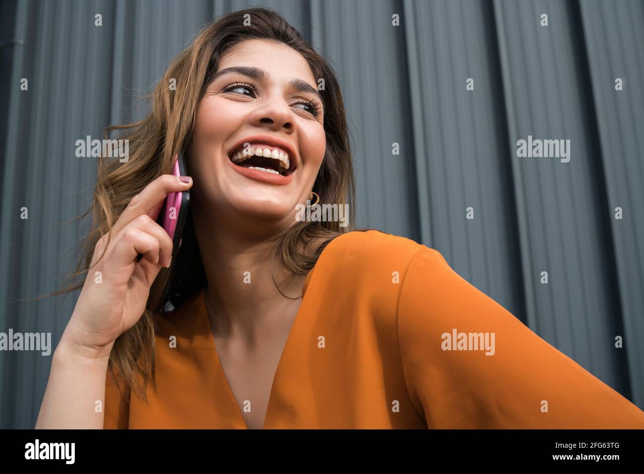 Jeune femme parlant au téléphone à l'extérieur. Banque D'Images