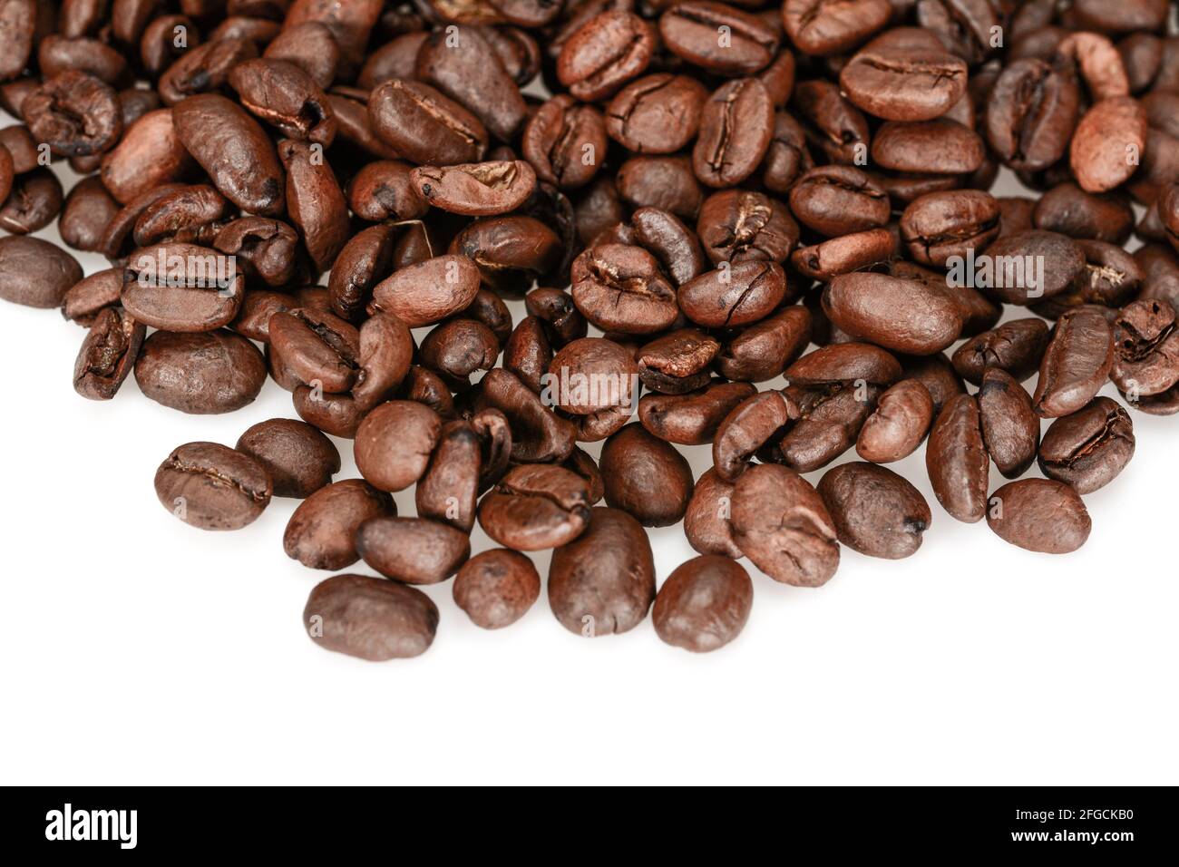 Grains de café torréfiés durs, marron foncé, isolés sur fond blanc Banque D'Images