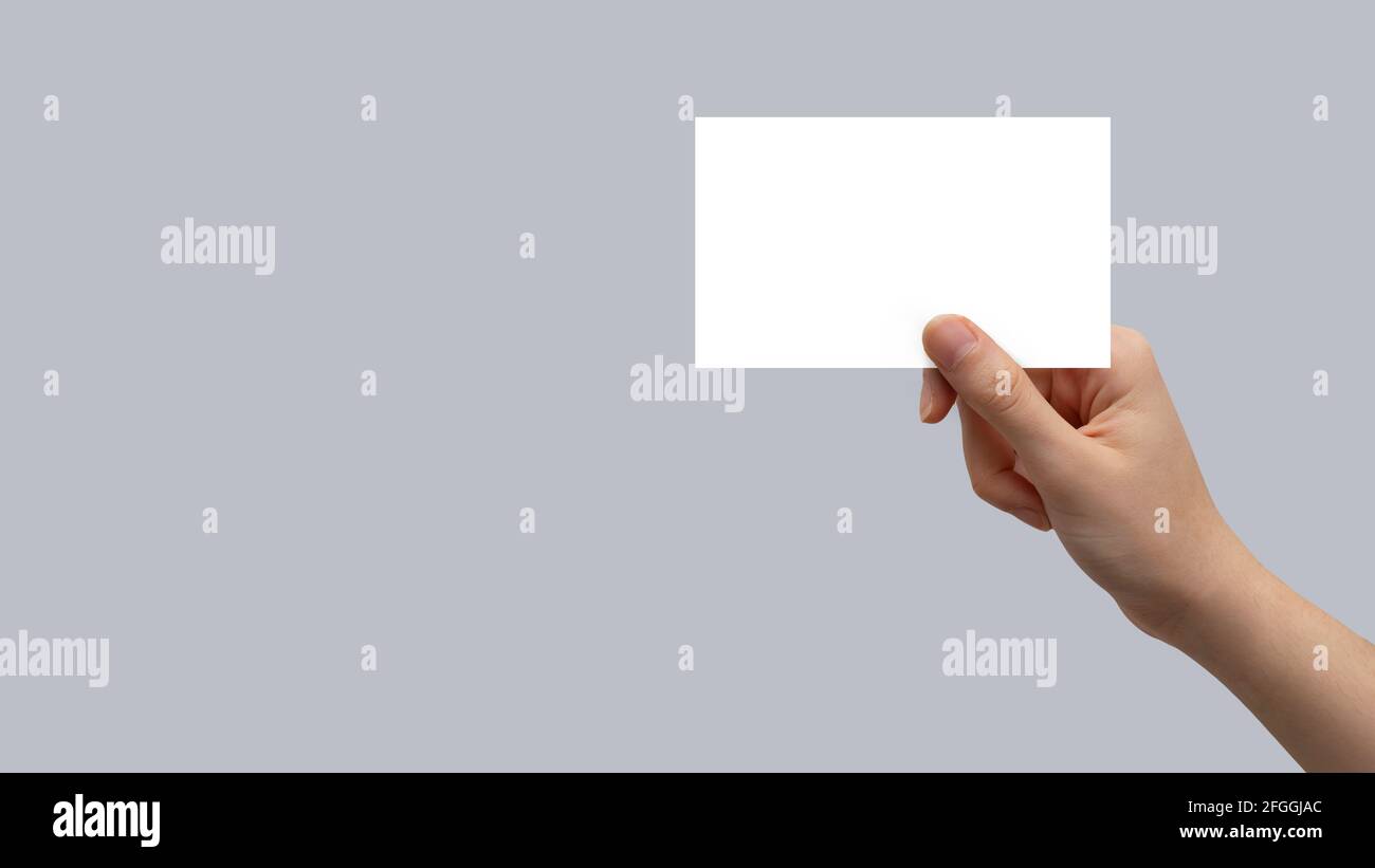 Main tenant la carte blanche sur un arrière-plan isolé Banque D'Images