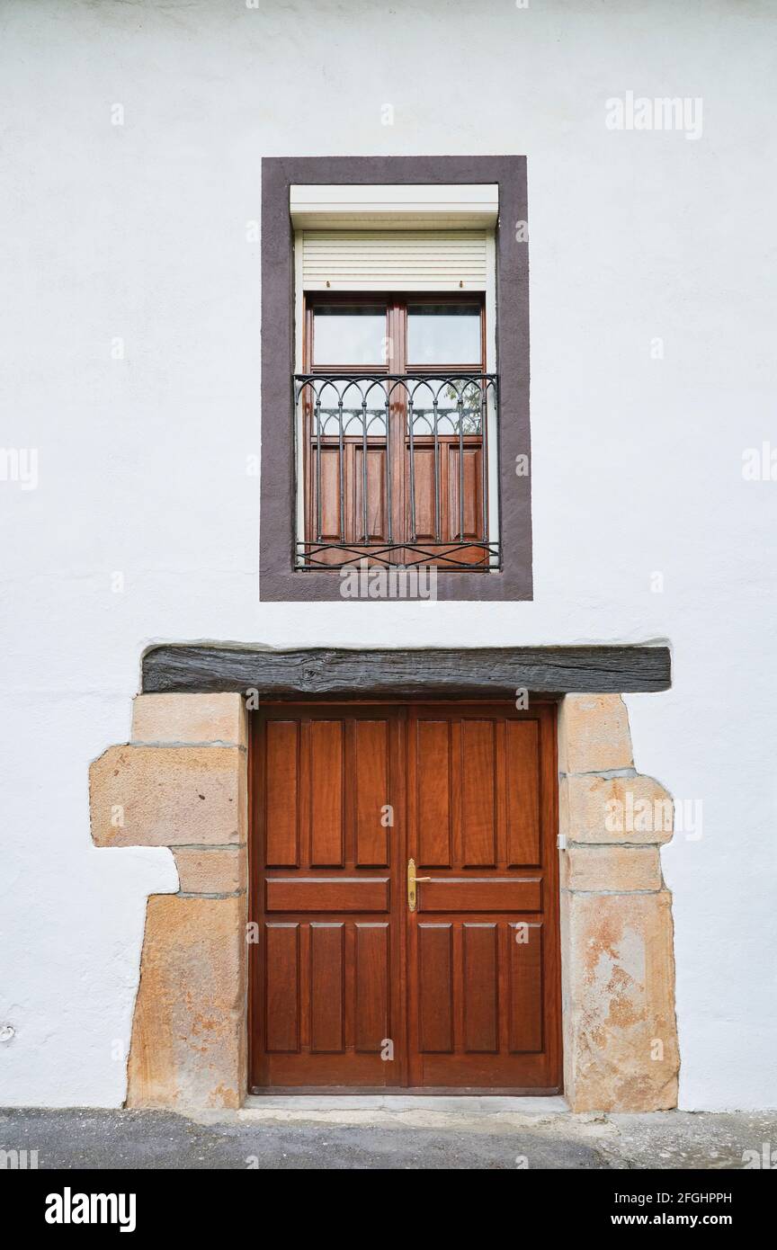 Façade blanche avec porte en bois et balcon Banque D'Images