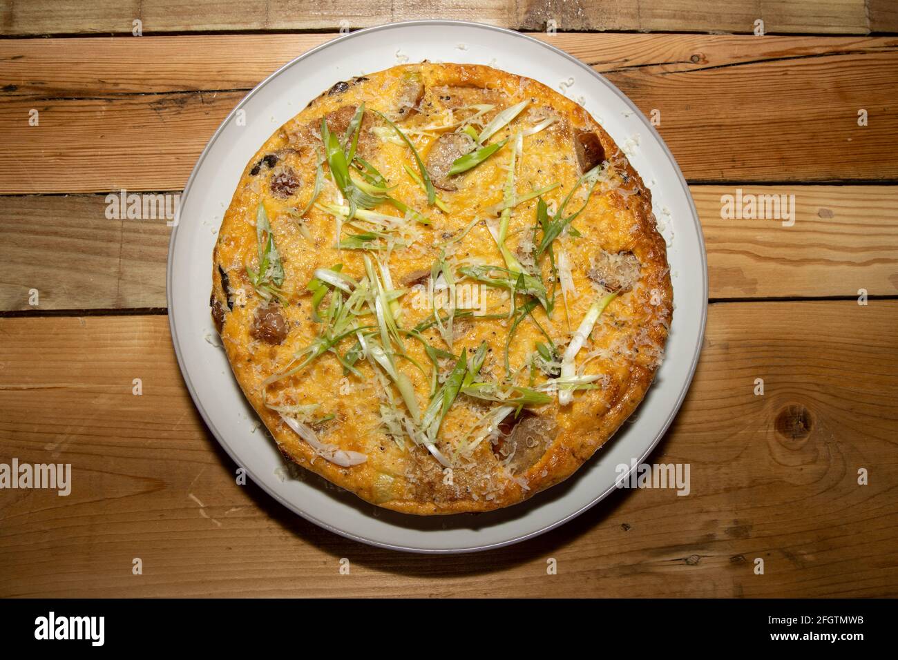Une délicieuse saucisse cuite et une frittata de Hash Brown sur un table de cuisine en bois Banque D'Images