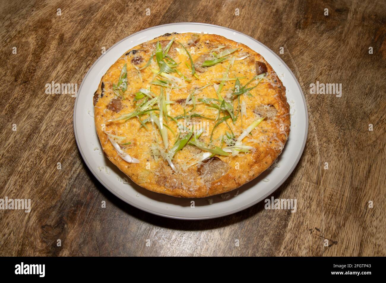 Une délicieuse saucisse cuite et une frittata de Hash Brown sur un table de cuisine en bois Banque D'Images