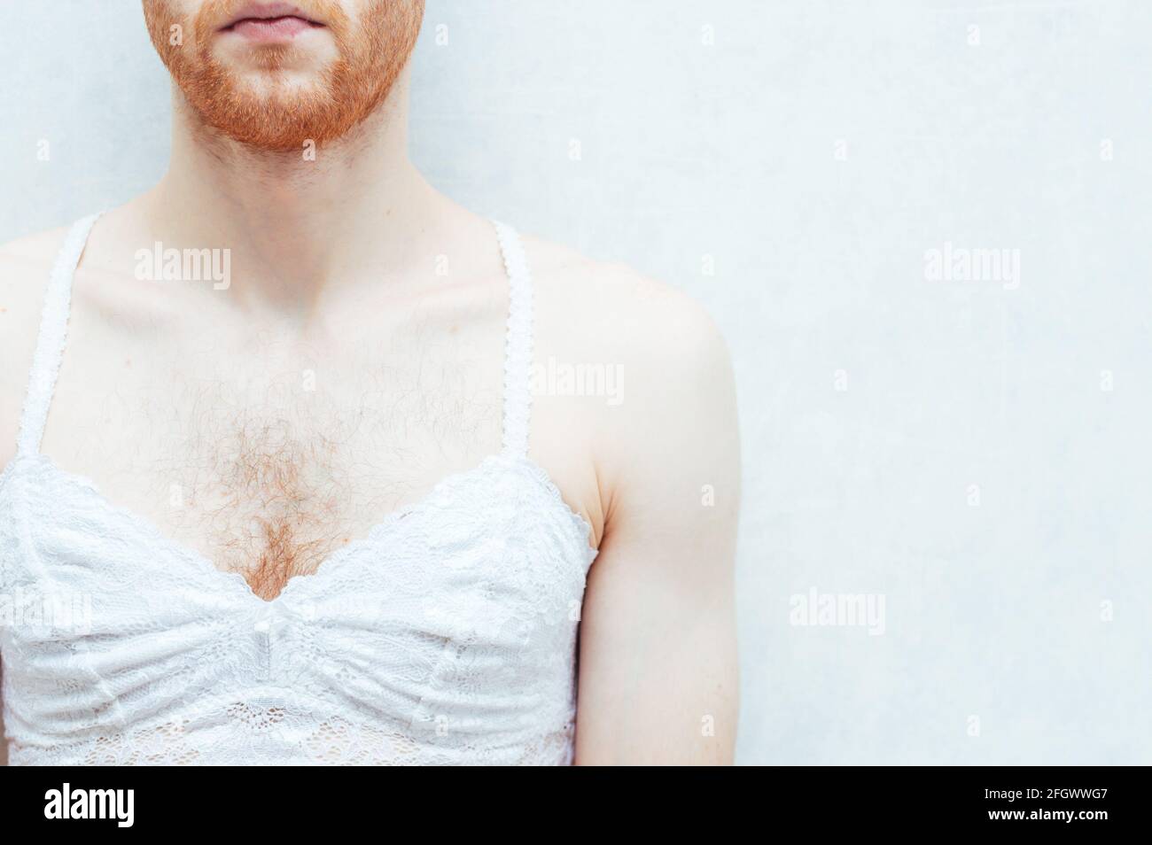Jeune homme en soutien-gorge blanc pour femmes. Gay Banque D'Images