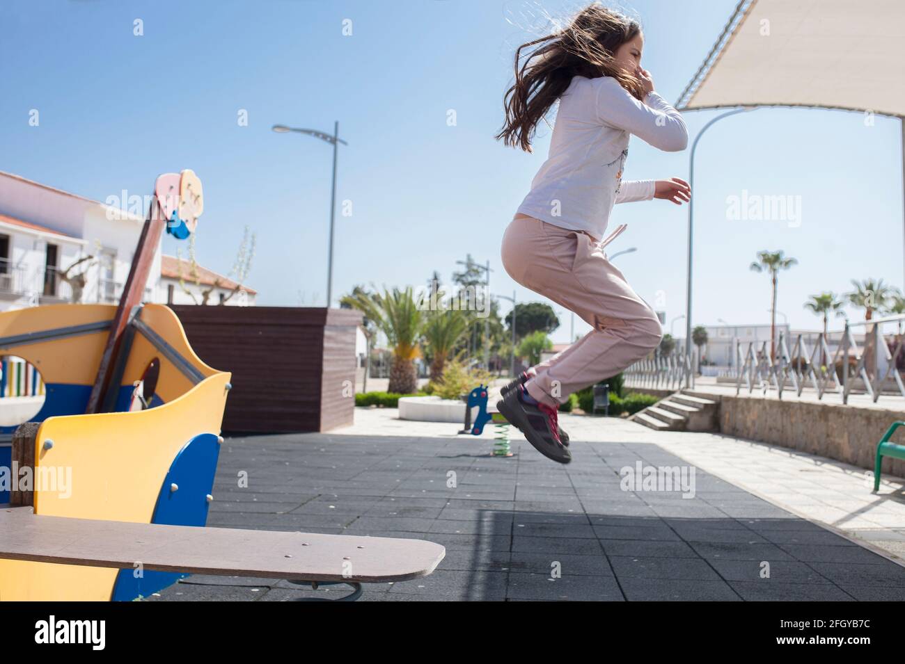 Enfant fille sautant de la marche la planche du bateau pirate de terrain de jeu. Vitalité et imagination concept pour les enfants Banque D'Images