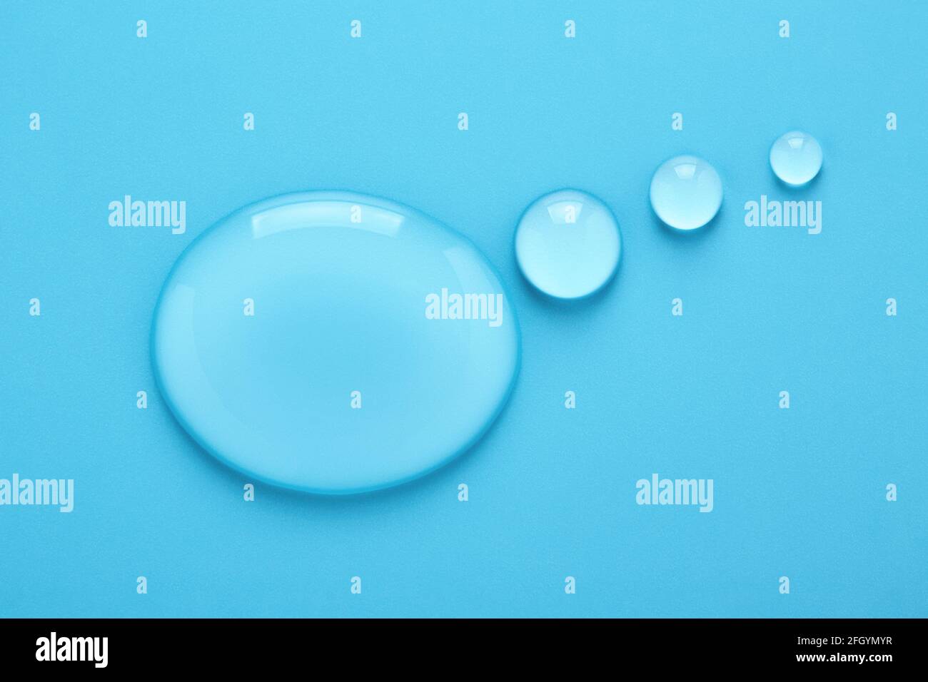 L'eau tombe en forme de bulle de pensée sur fond bleu. Banque D'Images