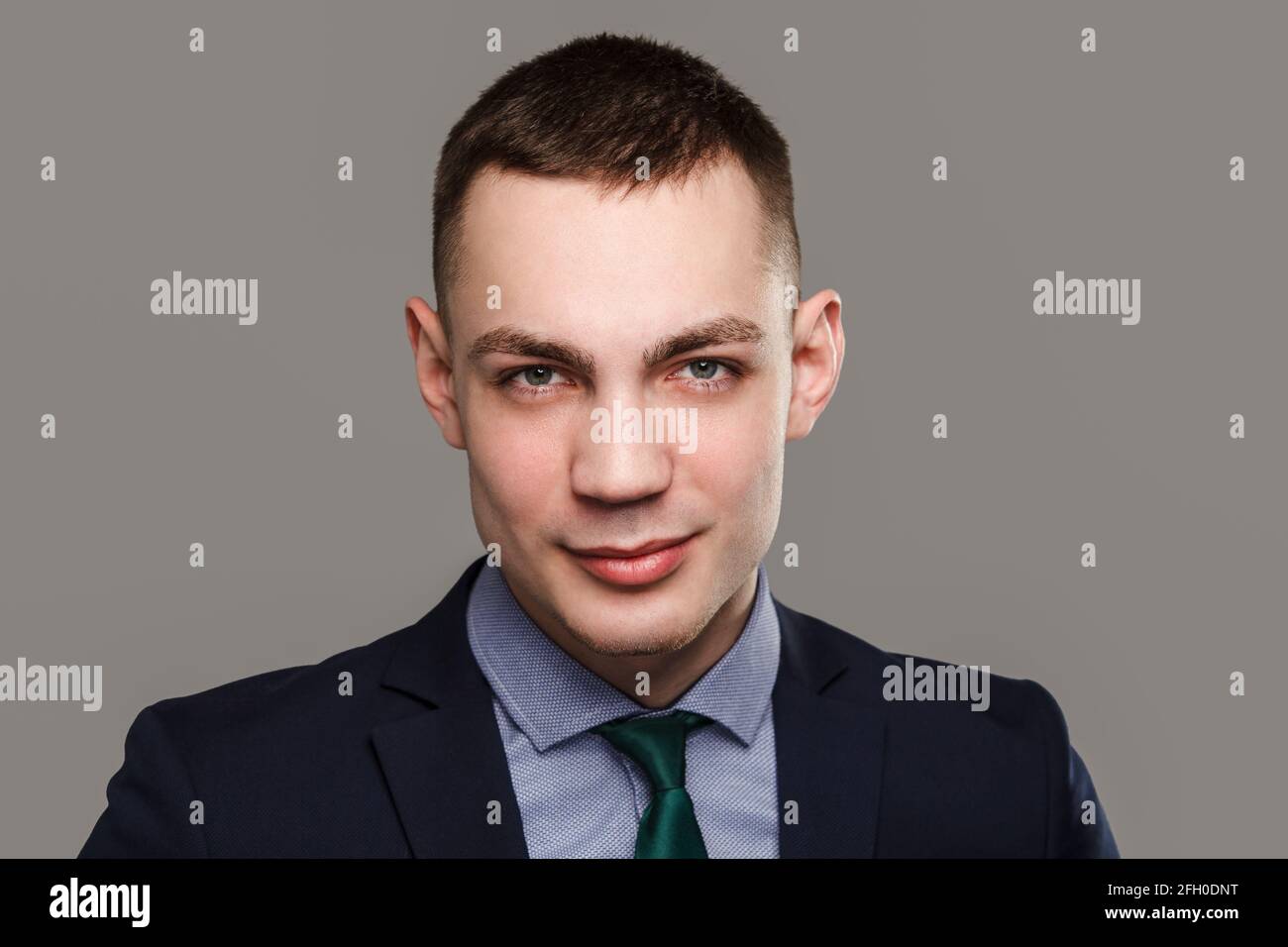 Jeune homme d'affaires sincère portrait isolé sur fond gris. Banque D'Images