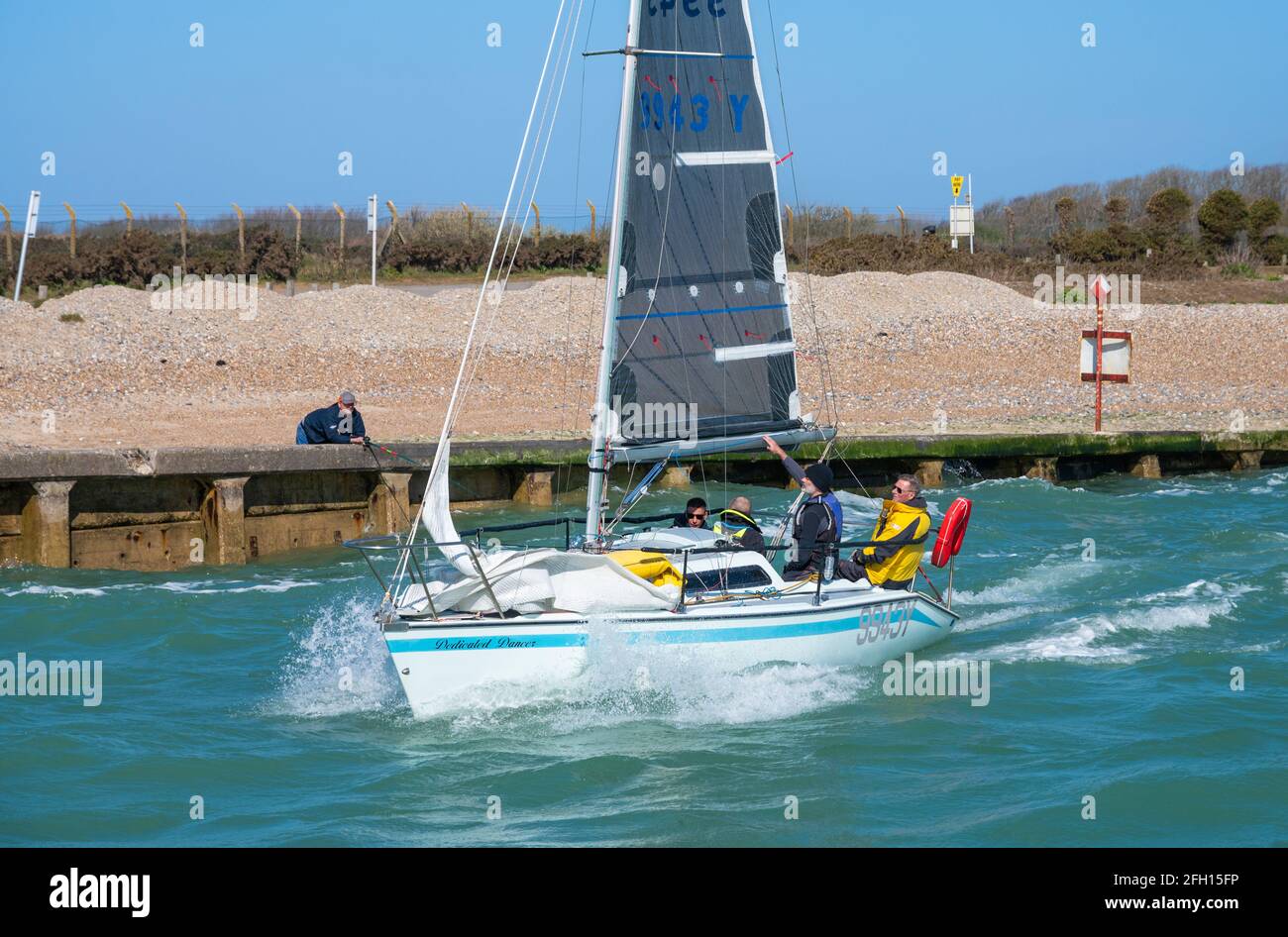 Groupe de personnes en voyage de voile sur un petit yacht, en train de remonter l'estuaire de la rivière Arun au printemps à Littlehampton, West Sussex, Angleterre, Royaume-Uni. Banque D'Images