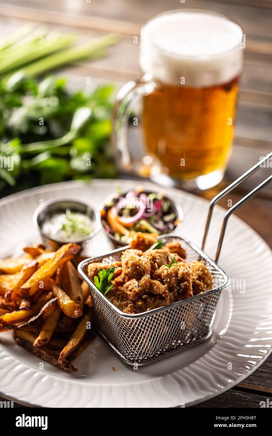 Nuggets de poulet frits avec frites, trempette, salade et bière. Banque D'Images